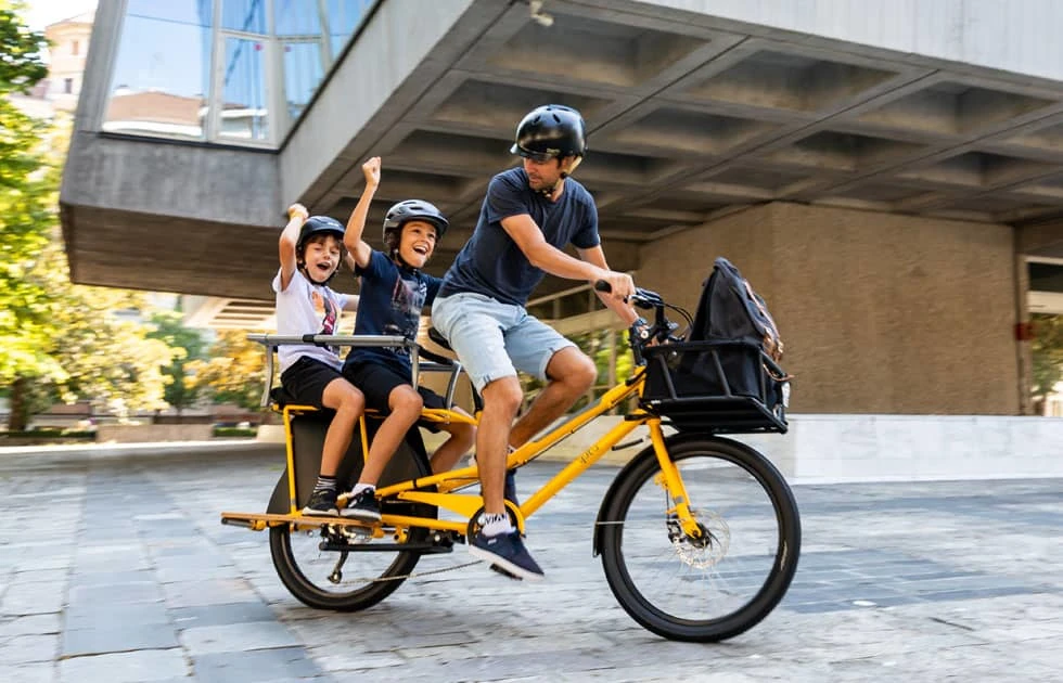 Homme faisant du vélo électrique avec ses enfants